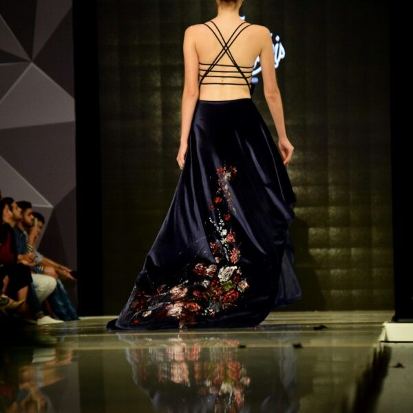 woman in black spaghetti strap dress standing on stage